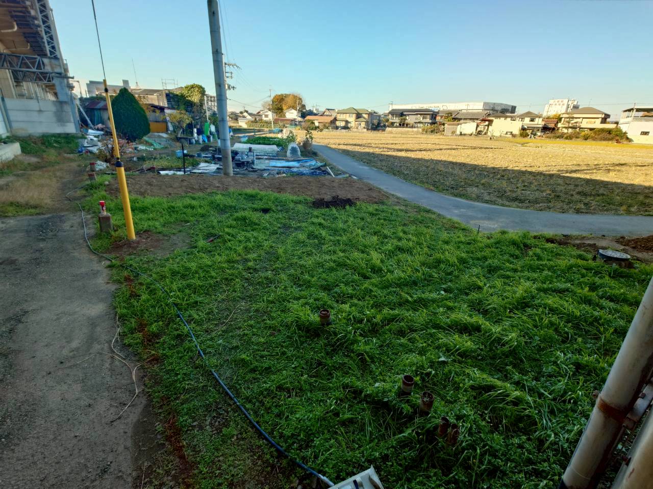 フェンス・アスファルト敷外溝工事の施工前の様子｜未舗装で通行性に課題がある敷地